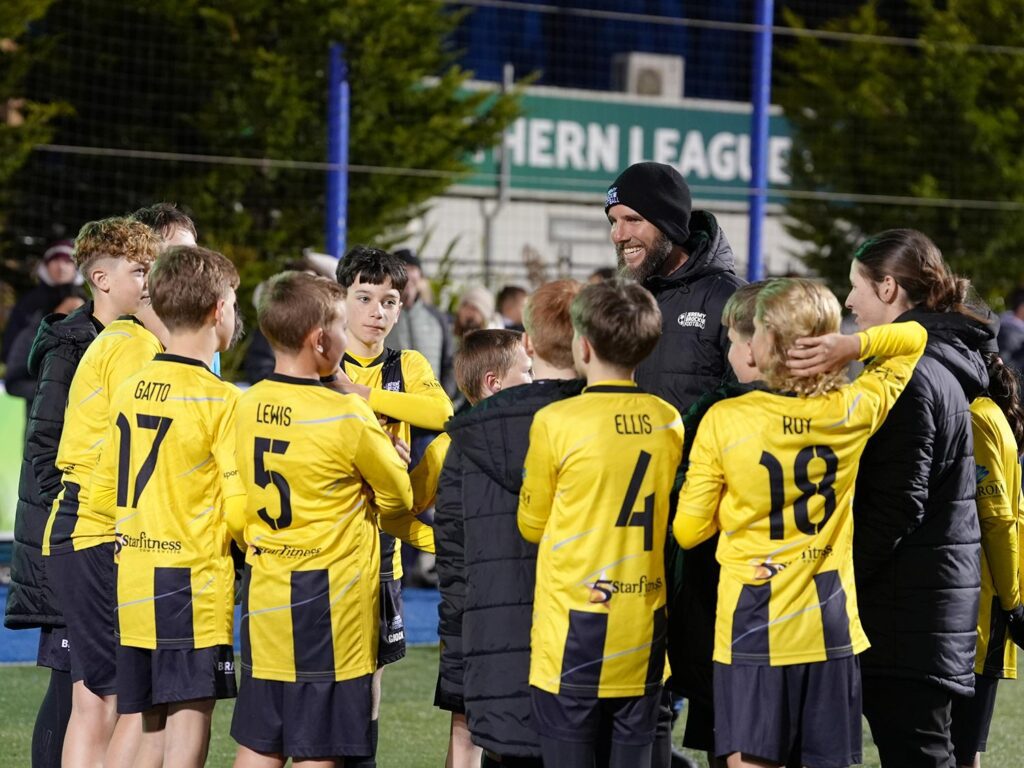 Jeremy Brockie with a team of young football players